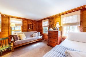 a bedroom with a bed and a couch and windows at Pretty on Prada in Edgartown +27 photos