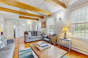 a living room with two couches and a table at Cozy Charming Cottage in Brewster