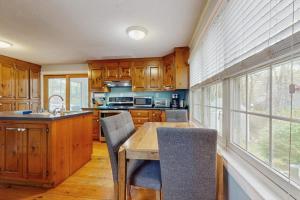 a kitchen with wooden cabinets and a wooden table at Cozy Charming Cottage in Brewster