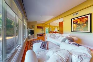 a living room with white couches and a large window at Yellow Brick Road House in Oak Bluffs