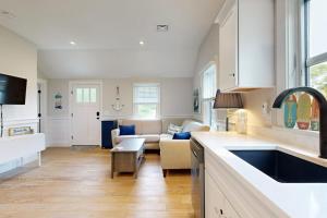 a kitchen and a living room with a couch at The Quintessential Cape Cottage in Orleans