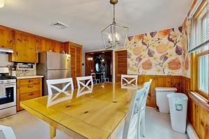 a kitchen with a wooden table and a refrigerator at Cape Beach Bungalow in Dennis Port
