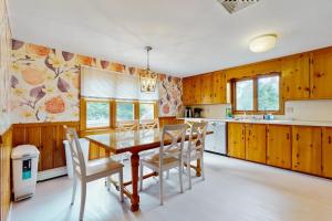 a kitchen with wooden cabinets and a table and chairs at Cape Beach Bungalow in Dennis Port