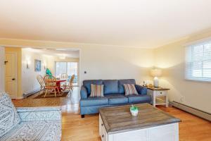 a living room with a blue couch and a table at Jesmond Cottage in Harwich