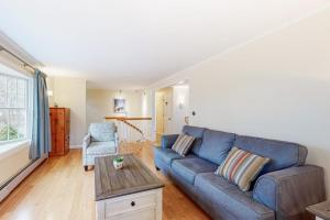 a living room with a blue couch and a table at Jesmond Cottage in Harwich