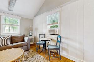a living room with a couch and a table and chairs at Salty Kisses Unit 20 in Yarmouth
