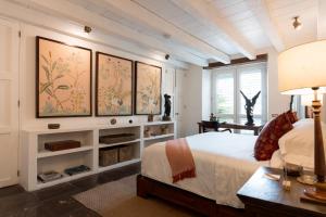 a bedroom with a bed and some paintings on the wall at Amarla Boutique Hotel Cartagena in Cartagena de Indias