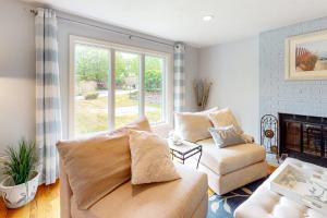 a living room with a couch and a fireplace at Birch Grove in Mashpee +36 photos