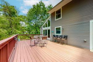 a wooden deck with a table and chairs on a house at Birch Grove in Mashpee