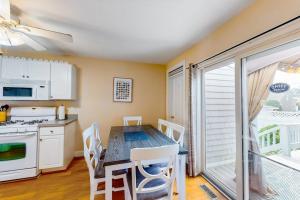 a kitchen with a dining room table with white chairs at Onset Grove in Onset