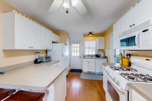 a kitchen with white cabinets and a stove top oven at Onset Grove in Onset