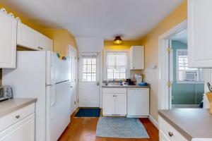 a kitchen with white cabinets and a white refrigerator at Onset Grove in Onset