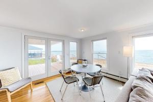 a living room with a table and chairs and the ocean at Kalmus Park Retreat in Hyannis