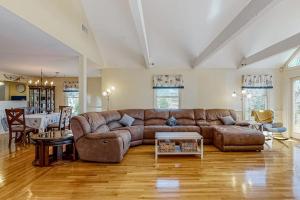 ein Wohnzimmer mit einem braunen Sofa und einem Tisch in der Unterkunft Lovells Landing in Cotuit