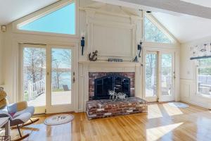 ein Wohnzimmer mit gemauertem Kamin und Fenstern in der Unterkunft Lovells Landing in Cotuit + 29 Fotos