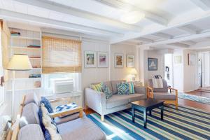 a living room with a couch and a table at Canary Cottage in Oak Bluffs