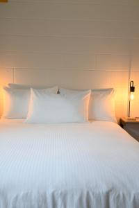 a large white bed with white pillows on it at Spahats Creek Resort in Clearwater