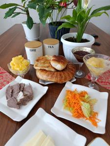 a wooden table with plates of food on it at Arzu Guesthouse in Ak-Say +14 photos