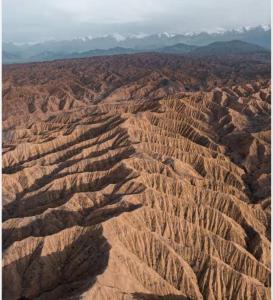 an aerial view of a desert with mountains in the background at Arzu Guesthouse in Ak-Say