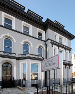 um edifício branco com um sinal em frente em Austens Apartments em Torquay