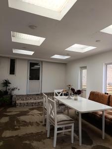 a room with a white table and chairs and a couch at Arzu Guesthouse in Ak-Say