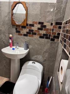 a bathroom with a white toilet and a sink at Apartamento REFUGIO DEL LAGO in San Pedro La Laguna +7 photos