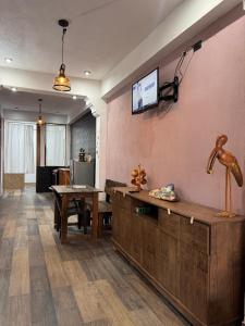 a living room with a table and a tv on the wall at Apartamento REFUGIO DEL LAGO in San Pedro La Laguna