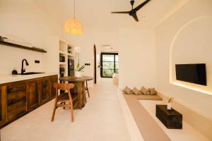 a kitchen with a counter and a table in a room at Rumah Mana Villa in Tabanan