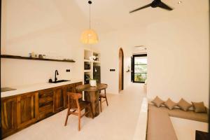 a kitchen and living room with a table and a couch at Rumah Mana Villa in Tabanan
