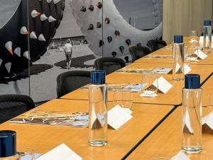 a row of wooden tables with wine glasses on them at Mercure Dieppe La Présidence in Dieppe