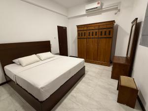 a bedroom with a bed and a wooden cabinet at Lucky Homes in Maharagama +31 photos