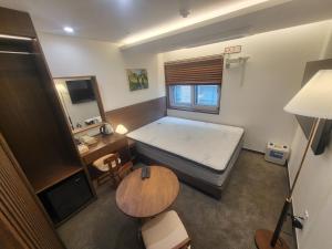 a small room with a bed and a table at LUVO Signature Hotel in Seoul +20 photos