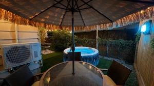 a table with an umbrella next to a hot tub at Tropical Casita LaVida in Tampa