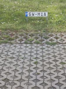 a sign sitting on the grass next to a sidewalk at Wohnung Mia in Sangerhausen