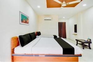 a bedroom with a large bed with a ceiling at Hotel O Grand Executive in Chikalthān