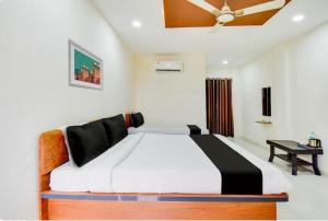 a bedroom with a large bed with a ceiling at Hotel O Grand Executive in Chikalthān +21 photos