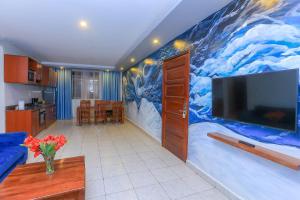 a living room with a large painting on the wall at Bon Bini Residence Apart-Hotel - Pool, Fast WiFi, Security, Backup Power in Kampala