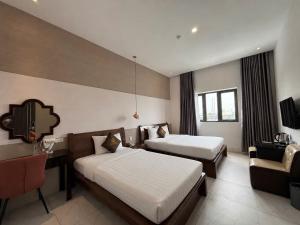 a hotel room with two beds and a desk at Glory Hotel in Can Tho +66 photos