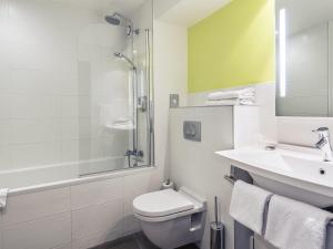 a bathroom with a toilet and a sink and a shower at Hôtel Mercure Thionville Centre Porte du Luxembourg in Thionville