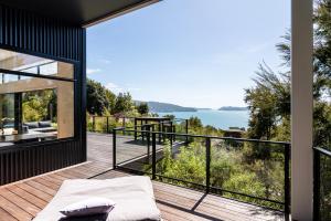 a house with a view of the ocean on a deck at Kokomea in Kaiteriteri