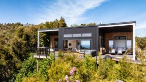 a black house on a hill with trees at Kokomea in Kaiteriteri