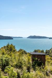 a small building next to a large body of water at Kokomea in Kaiteriteri