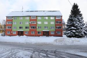 ein großes Gebäude mit Schnee auf dem Boden neben einer Straße in der Unterkunft Liked home in Pernink