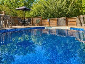 a swimming pool with an umbrella and a table and chairs at South Shore Suites in Bayfield