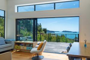 a living room with a table and a large window at Kokomea in Kaiteriteri +45 photos