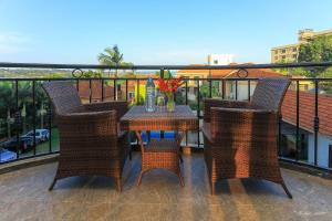 a patio with a table and chairs on a balcony at Bon Bini Residence Apart-Hotel - Pool, Fast WiFi, Security, Backup Power in Kampala