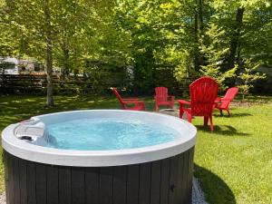 a hot tub in a yard with red chairs at South Shore Suites in Bayfield