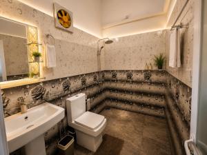 a bathroom with a toilet and a sink at Rainbow Safari & Lodge in Udawalawe +46 photos