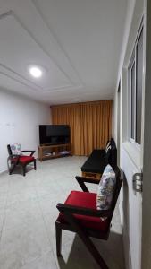 a living room with two chairs and a flat screen tv at ApartahotelVacacionalSangil in San Gil