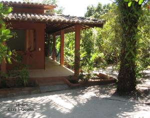 un porche de una casa con un árbol en Condominio dos Nativos, en Trancoso